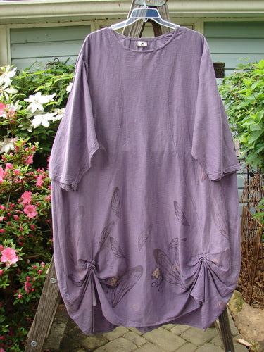 Barclay Hemp Cotton Silk Voile Belle Dress Wing Violet Size 2, displayed on a clothesline, showcasing its wide neckline, dramatic back yoke, and intricate wing and flower pattern.