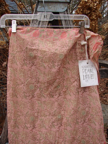 Magnolia Pearl NWT European Cotton MP Block Print Scarf Rosette hangs gracefully, showcasing a delicate floral and leaf pattern on lightweight batiste fabric, with a Magnolia Pearl tag and contrasting border.