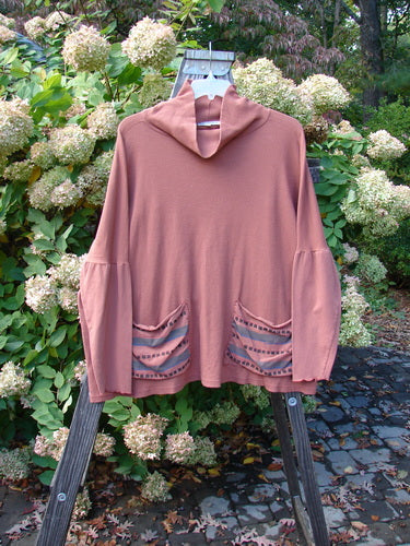 Barclay Patched Thermal Tie Back Cowl Top Dusty Brick Size 3 displayed on a wooden stand, featuring a loose double cowl turtleneck, exterior pockets, dolmen sleeves, and painted patches.