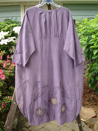 Barclay Hemp Cotton Silk Voile Belle Dress Wing Violet Size 2 displayed on a clothesline, featuring wing and flower designs, dramatic back pleats, and a bell shape with dual vertical ruching.