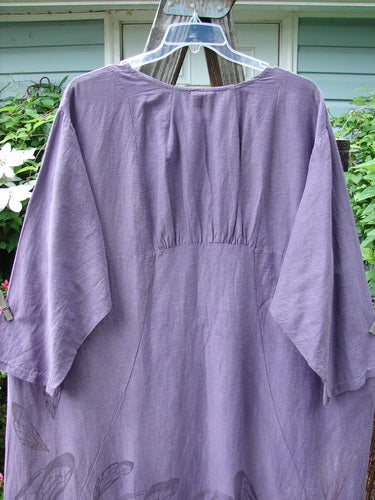 Barclay Hemp Cotton Silk Voile Belle Dress Wing Violet Size 2 displayed on a clothes hanger, showcasing its intricate figure 8 vertical seams and dramatic rear reverse yoke backline with upper pleats.