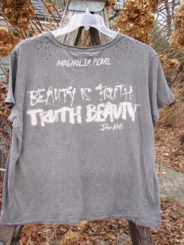 Magnolia Pearl NWT Cotton Jersey Boyfriend Tee MP Malibu Ozzy OSFA, featuring BEAUTY IS TRUTH, TRUTH BEAUTY by John Keats, displayed outdoors with slight shoulder distressing, emphasizing a unique, expressive style.