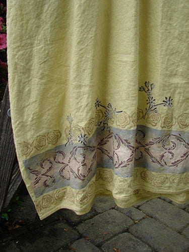 Barclay Linen Cotton Sleeve Banded Hem Pleat Dress Falling Sprig Plantain Size 2 displayed against a floral yellow towel backdrop, showcasing its pleated design, rounded neckline, and three-quarter sleeves.