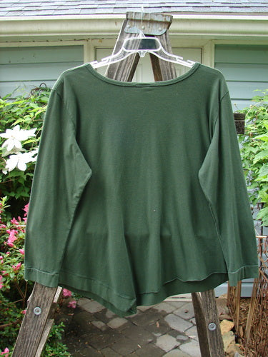 Barclay NWT Cotton Lycra Keyhole Pullover Top in Rich Clover displayed on a clothes rack, showcasing its long sleeves, angled flutter hem, and keyhole center accent.