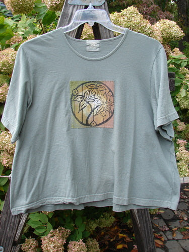 1999 Patched Short Sleeved Crop Tee Tri Floral Shale Size 2, featuring a classic floral graphic design and a feminine rolled neckline, crafted from organic cotton. Perfect for a casual, vintage-inspired look.