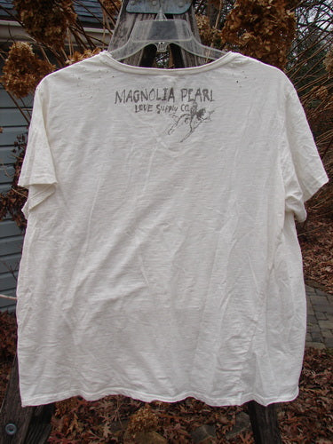 Magnolia Pearl Cotton Jersey Short Sleeved Boyfriend Tee True OSFA, featuring 'MAGNOLIA PEARL' and 'Love Supply Co.' text on the back, hanging outdoors. The tee is lightweight with rolled edges and shoulder distressing.