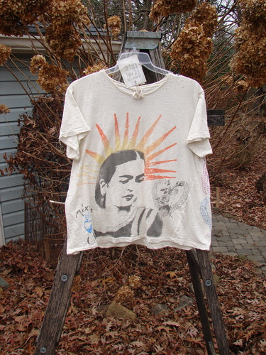 Magnolia Pearl NWT Cotton Jersey Boyfriend Tee Frida Del Sol True OSFA features a stylized woman's portrait with sunburst lines, doodle elements, rolled edges, and shoulder distressing, displayed on a wooden ladder.
