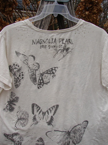 Magnolia Pearl NWT Cotton Jersey Boyfriend Tee Beyond Butterflies True OSFA features screen-printed MAGNOLIA PEARL Love Supply Co. and butterfly collage on the back, showcasing its unique design and drapey feel.