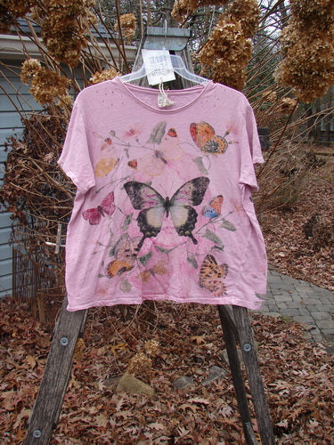 Magnolia Pearl NWT Cotton Jersey Boyfriend Tee Profound Responsibility Allium OSFA, featuring butterfly and floral motifs, displayed on a hanger outdoors, showcasing its drapey, soft texture, and unique design elements.