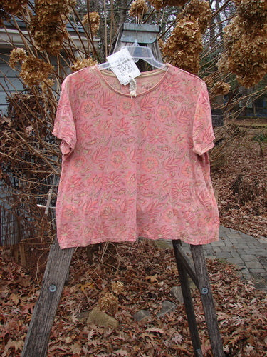 Magnolia Pearl NWT Cotton Jersey Boyfriend Tee Remi Block Print Sunset Flower OSFA, featuring a loose fit and subtle floral print, hangs on a ladder outdoors, showcasing its soft texture and unique design details.
