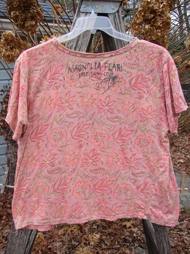 Magnolia Pearl NWT Cotton Jersey Boyfriend Tee Remi Block Print Sunset Flower OSFA, featuring a leaf-floral motif, distressed shoulder detailing, and a signature back stamp, draped on a clear hanger outdoors.