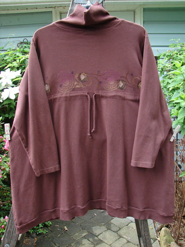 Barclay Interlock Turtleneck Pullover Tunic Top Celtic Paisley Sepia Size 2 on a hanger, showcasing long sleeves, ribbed turtleneck, A-line shape, ribbed hem, and side entry pockets.