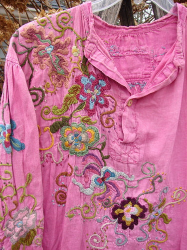 Magnolia Pearl Embroidered Linen Gypsy Johnny & Co Shirt Pinkster OSFA features intricate multicolored floral embroidery on a pink tunic with a loose neckline, button placket, and billowy sleeves.