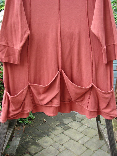 Barclay Thermal Quad Drop Pocket Tunic Dress Unpainted Brick Size 2 displayed on a wooden ladder, showcasing its double-layered flop turtleneck and varying hemline.