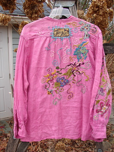 Magnolia Pearl Embroidered Linen Gypsy Johnny & Co Shirt Pinkster OSFA features vibrant multicolored floral embroidery on the back and sleeve, showcasing intricate designs on a lightweight, long-sleeved button-front shirt.