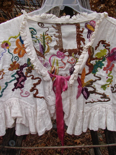 Magnolia Pearl Embroidered Linen Ruffle Ribbon Bolero White OSFA features multicolored floral embroidery, ruffled edges, and a pink ribbon closure, showcasing the store's vintage-inspired, creative fashion spirit.