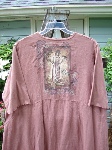 Barclay Linen Cotton Sleeve Banded Hem Pleat Dress Bird Gal Dusty Mauve Size 2 hanging on a clothes hanger, featuring a drawing of a woman holding two bowls on the front.