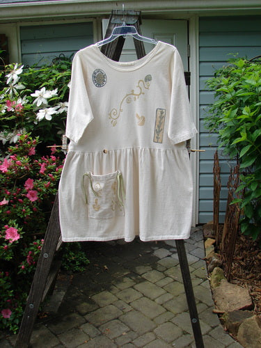 1994 Flower Garden Dress Sun Garden Tea Dye Altered Size 2 displayed on a rack, featuring a scooped neckline, drop waist, and pocket, with whimsical floral paint accents.