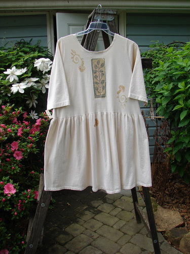 1994 Flower Garden Dress Sun Garden Tea Dye Altered Size 2 displayed on a clear plastic hanger, featuring a floral design with a scooped neckline and generous fabric folds.