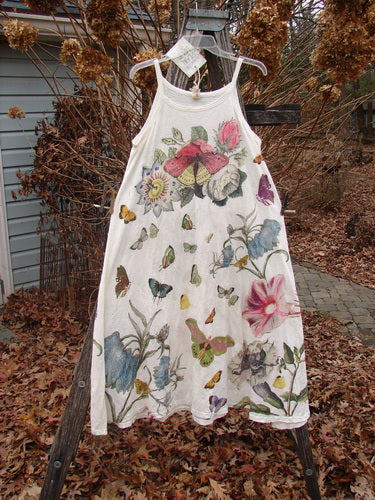 Magnolia Pearl NWT Cotton Jersey Lana Tank Dress Flor Da La Pasion True OSFA, featuring a sleeveless design with colorful floral and butterfly prints, hanging outdoors with raw edges and distressed details.