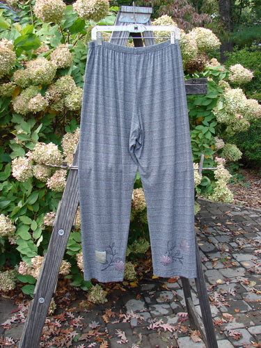 Pair of 2000 Rayon Lycra Stripe Duo Cliffshadow Stripe Size 2 pants displayed on a wooden ladder outdoors.