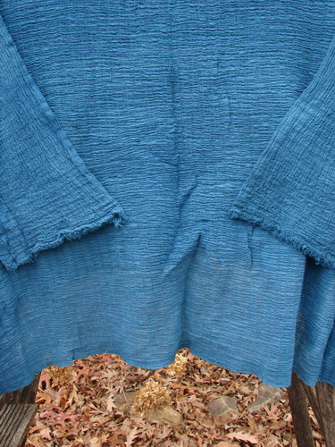 Barclay NWT Crinkle Gauze Top Mottled Teal OSFA draped to showcase scalloped cuffs and hem, capturing its lightweight texture and elegant design amidst scattered leaves, reflecting Bluefishfinder.com's vintage, expressive ethos.