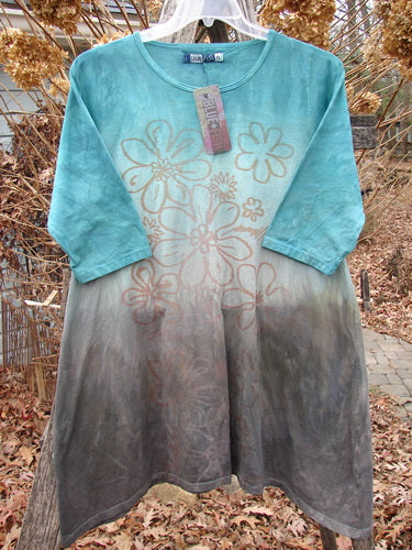 Barclay NWT Wander Tunic Tee Contour Daisy Logo Bolsena Size 0, featuring a gradient ombre design, three-quarter sleeves, rounded neckline, and faded floral stencil, hanging outdoors on a plastic hanger.