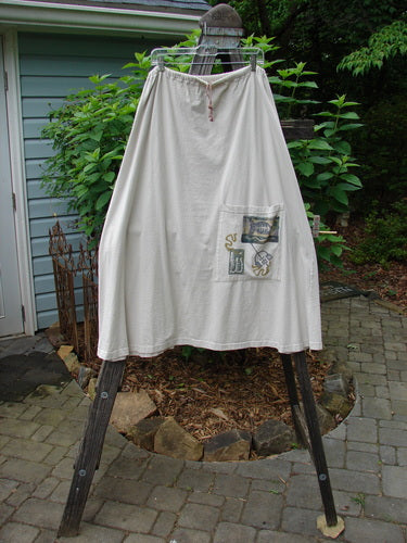 1994 Everywhere Skirt Magical Fish Mist Size 1 displayed on a wooden stand, showcasing its full A-line shape, lower front pocket with Diamond Fern accents, and drawcord waistline.