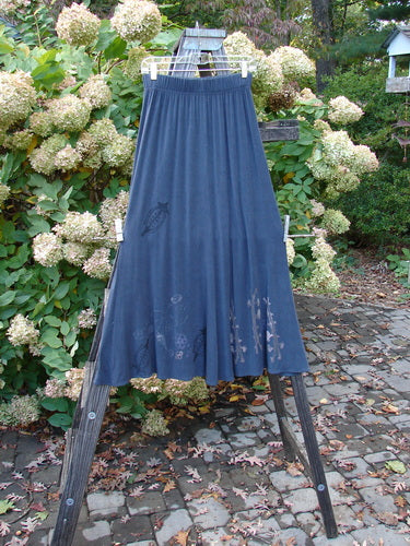1998 Rayon Lycra Botanicals Tendril Mayflower Duo Onyx Size 1: A blue skirt on a clothes rack, part of the Spring Collection.