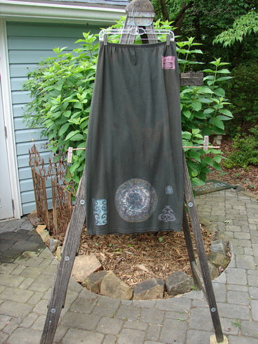 1992 Straight Skirt Holiday Metallic Medallion Black Sand Size 1 displayed on a wooden frame, showcasing its full elastic waistline and metallic medallion theme.