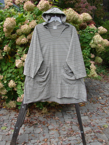Grey striped 2000 Resort Hooded Pocket Pullover Zig Zag Black Olive Grey Stripe Size 2 displayed on a wooden stand, showcasing its A-line shape and oversized hood.