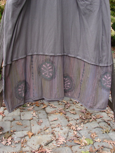 Barclay Pleated Banded Bottom Sweep Dress Celtic Fern Mushroom Size 1 displayed on a bench, showcasing its pleated neckline, sectional sleeves, and detailed fern graphics in a sweeping A-line shape.