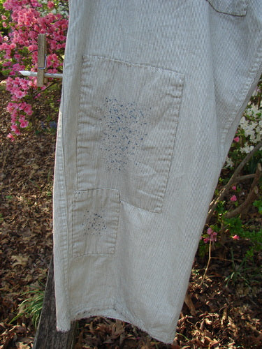 Magnolia Pearl NWT European Denim Lilou Trouser Natural Pinstripe OSFA features light-colored pinstriped fabric with dual patch pockets and dark paint spots, showcasing adjustable details for versatile styling.