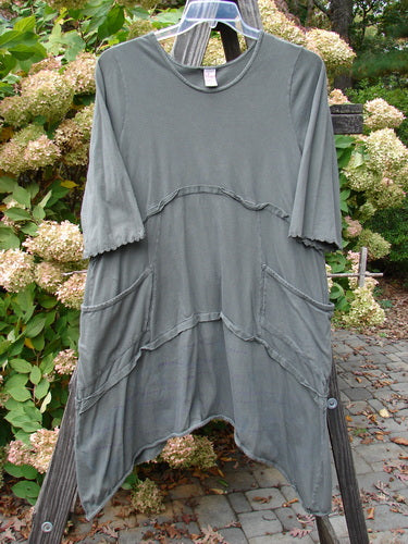 Barclay Cotton Lycra Raw Edge Vector Pocket Tunic Dot Grey Green Size 1 displayed on a hanger, featuring three-quarter sleeves, two exterior pockets, and a varying hemline with a rounded V-shaped neckline.