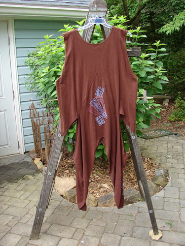 Barclay Calligrapher's Vest in Sepia with unique shape and dramatic sides, displayed on a wooden ladder. Features deep V-neckline, vintage buttons, and detailed Asian-inspired forest theme design.