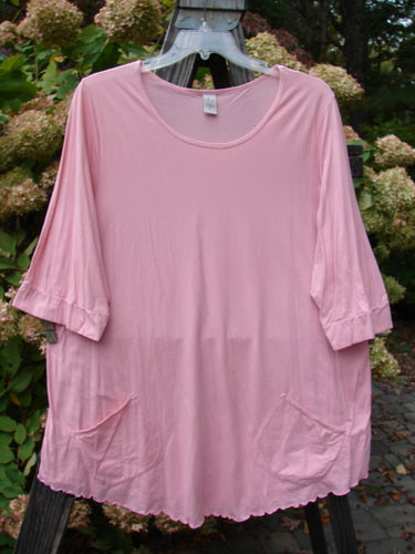 Barclay Twinkle Pocket Top, size 2, featuring a pink shirt with angular front drop pockets, banded lower sleeves, and a sweet curly edge.