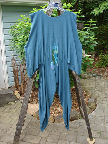 Barclay Calligrapher's Vest in Deep Tealen, displayed on a wooden ladder, showcasing unique shape, deep V neckline, and vintage buttons.