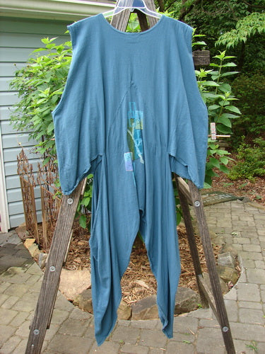 Barclay Calligrapher's Vest in Deep Tealen, size 2, displayed on a wooden ladder, showcasing its unique shape, open hips, deep V-neckline, and vintage buttons.