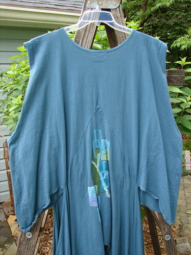 Barclay Calligrapher's Vest Asian Inspiration Deep Tealen Size 2 displayed on a wooden fence, showcasing its unique shape, open hips, deep V neckline, and vintage buttons.