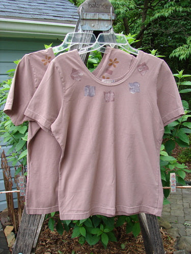 2000 Cotton Lycra Short Sleeved Layering Tops Necklace Coralline Size 1, displayed on hangers, showcasing their fitted, shapely design with a rounded neckline and superior stretch fabric.