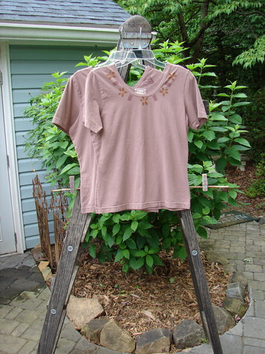 2000 Cotton Lycra Short Sleeved Layering Tops Necklace Coralline Size 1 displayed on a clothes rack, showcasing their fitted, shapely design and rounded feminine neckline suitable for layering.