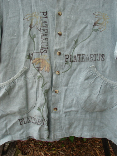 Close-up of the 1998 Botanicals Robin's Top Platearius River Size 0, showcasing dual front elastic-topped pockets, a super A-line shape, and seven tiny buttons on heavy-weight linen fabric.