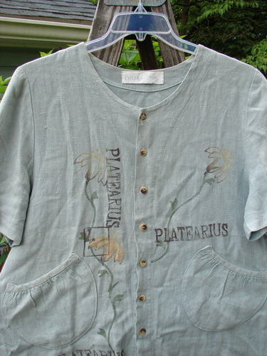 1998 Botanicals Robin's Top Platearius River Size 0 displayed on a hanger, showcasing a unique garden-themed design, dual front pockets, and seven buttons on a heavyweight linen fabric.
