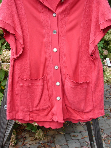 Barclay Celtic Moss Hooded Pocket Cardigan in Geranium, featuring short sleeves, a floppy hood, two lower pockets, curly edgings, and a full button front. Size 0, medium weight, 34 inches long.