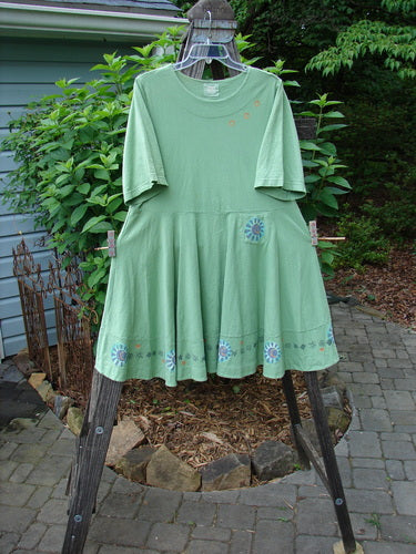 1999 Nest Dress Sun Border Spearmint Size 0 displayed on a clothes rack, showcasing its paneled neck, short sleeves, and swingy lower hem.