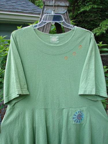 1999 Nest Dress Sun Border Spearmint Size 0, displayed on a hanger, featuring a paneled neck, short springy sleeves, and a swingy lower hem with a sweet painted upper hip pocket.