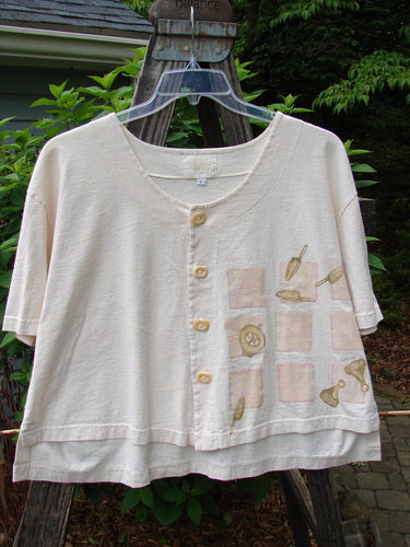 2001 Button Crop Top Game Garden Natural Size 1: White organic cotton shirt with buttons, a boxy shape, wide short sleeves, varying hemline, and unique painted garden-themed design.