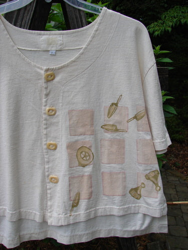 2001 Button Crop Top Game Garden Natural Size 1 features a graphic design, boxy style, wide short sleeves, rounded neckline, and unique buttons, embodying the creative spirit of BlueFishFinder.com.