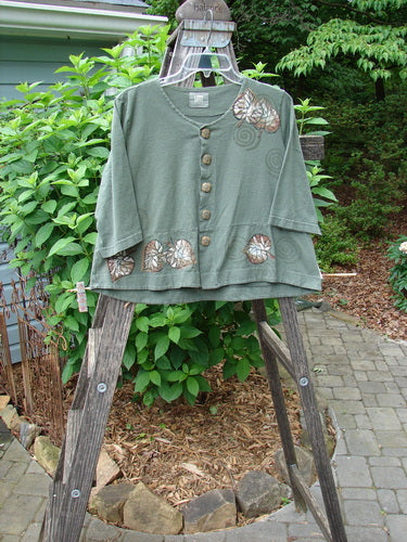 2000 4 Corners Jacket Leaf Green Lake Size 0 displayed on a wooden ladder, showcasing its flared shape, floral buttons, and double-paneled hem, embodying Bluefishfinder's vintage, creative style.