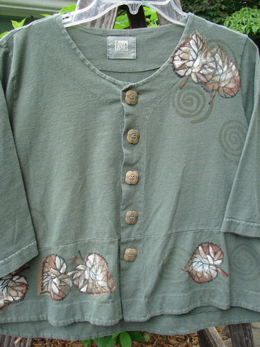2000 4 Corners Jacket Leaf Green Lake Size 0: Medium weight organic cotton jacket featuring brown leaf designs, floral blue buttons, and a flared, cropped shape with a double-paneled hem.